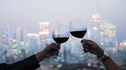 Close up of Young couple have romantic dinner on the rooftop with city as bokeh background