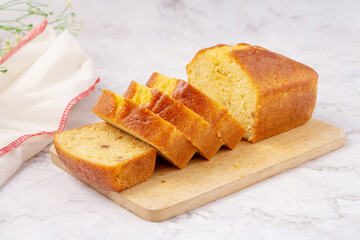 Sliced pound cake with lemon glaze on a cutting board.