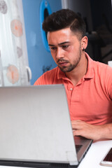 Young man working at home with a laptop.