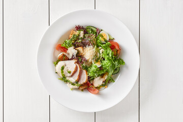 Caesar salad with vegetables, egg, croutons, chicken and Parmesan cheese