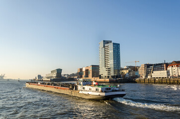 Scenic waterfront and industrial boat on the Elbe river in Hamburg, Germany