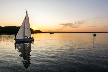 Sailing boats drifting back into the harbour during scenic sunset at the Baltic Sea