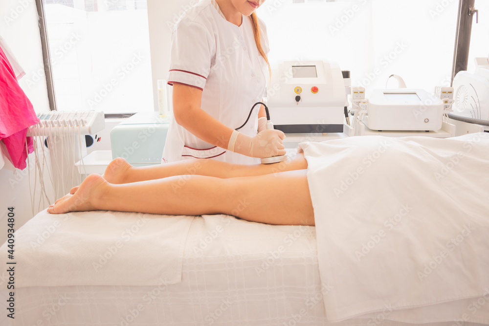 Poster Female physical therapist doing ultrasonic cavitation therapy on a woman in the spa