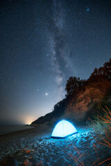 Amazing night view with Milky Way galaxy, starry sky and a tent at a sandy beach, Black sea coast, Bulgaria
