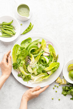 Vegan detox green salad with avocado dressing, top-down view