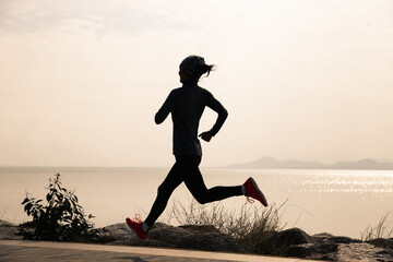 Fitness woman running on winter coast