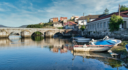 Fototapeta na wymiar Barcas de pescador y puente medieval de Ponte Sampaio sobre el río Verdugo en la provincia española de Pontevedra