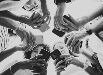 Obraz premium Young adults using smartphones in a circle social media and connection concept