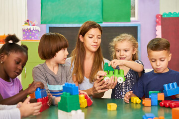 Group of children plays in kindergarten with an educator