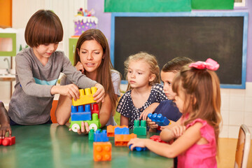 Children and educator play together with building blocks