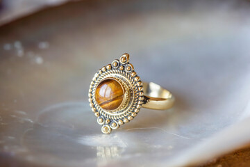 Brass ring in Indian oriental style on natural neutral shell background