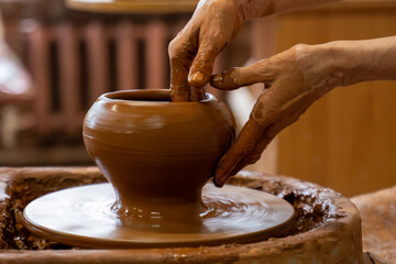 Elderly hands of a potter, creating an earthen jar on the circle. Old woman makes hand made ceramics from clay