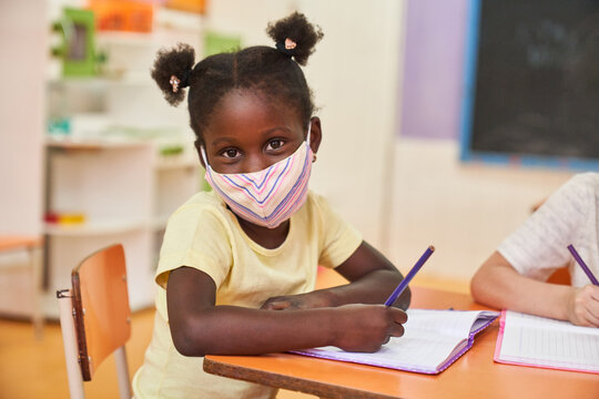 Girl with protective mask in elementary school