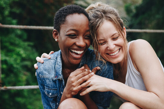 Two girl friends laughing and embracing each other