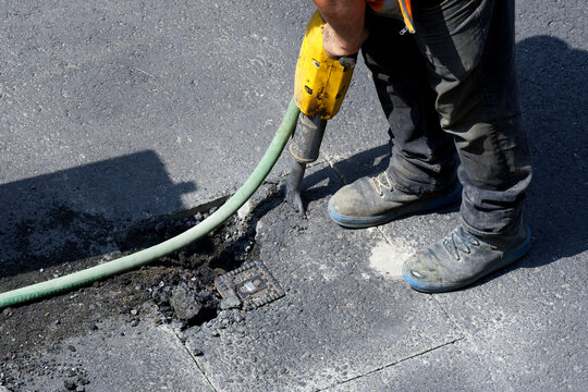road works on a gas pipeline, prising up the asphalt of a road with a jackhammer to expose a gas connection