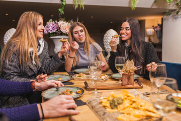 Group of friends eating at a dinner party at restaurant
