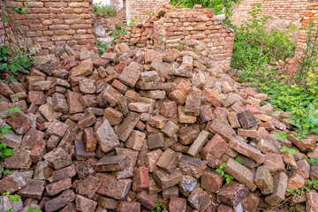 A pile of broken red building bricks is scattered on the ground. 