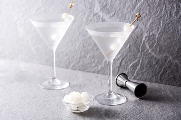 Gibson martini cocktail with onions on gray stone