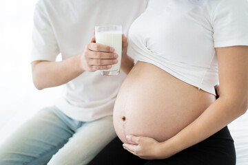 Lovely Asian couple taking care together in their house, husband taking care his pregnant wife.