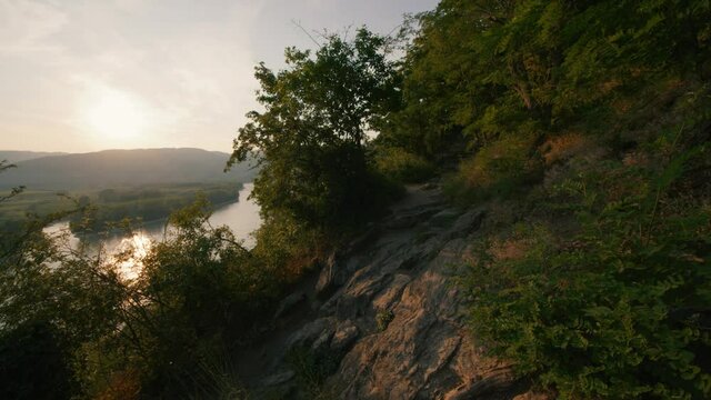 Rotating aerial pan shot of idyllic tropical forest with trees and lush green rain forest and river. Dramatic views of rock, valley, landscape, green rainforest jungle. Adventure, freedom, fun concept