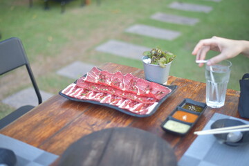 Meat in blak bowl on wood table.