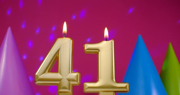 Burning birthday cake candle number 41. Happy Birthday background anniversary celebration concept. Birthday hat in the background