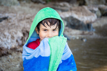 Boy wrapped in towel after swimming in the sea. Summer beach vacation concept. Holidays in France.