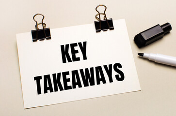 On a light background, a black open marker and on black clips a white sheet of paper with the text KEY TAKEAWAYS