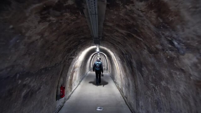 Photohraper walking in the old tunnel from WW2 under the center of Zagreb, Croatia