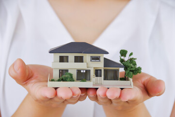 住宅の模型を持つ女性