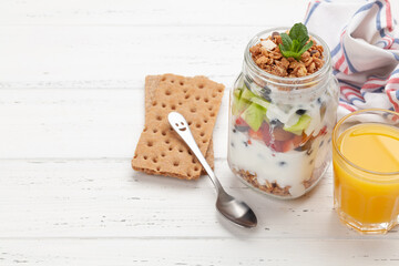 Healthy breakfast with jar of granola, yogurt and fresh berries