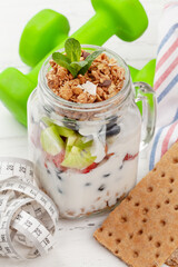 Healthy breakfast with jar of granola, yogurt and fresh berries