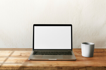 Laptop and coffee mug on wooden table