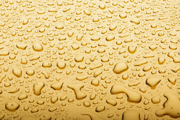Drops on a gold background. A spray of moisturizing spray from above