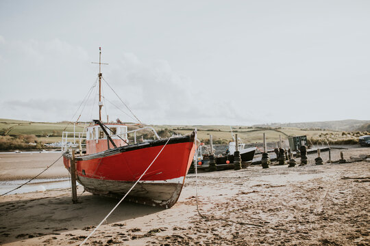 Sailboat Stranded On A Beach During Ebb, Wales, UK