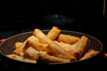 deep fried spring rolls  surve on the pan in dark background