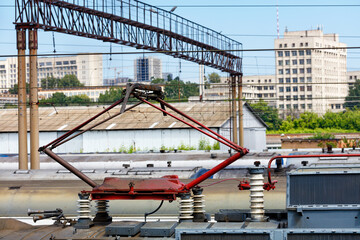 Naklejka premium Terminal connector on the roof of an old electric train against the background of a cityscape in blur.