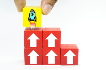 Colored cubes with up arrow and rocket start. The concepts of startups, income and success