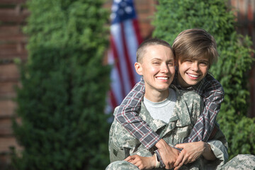 Happy reunion of female mother soldier with family son outdoors