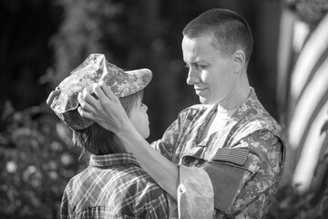 Happy reunion of female mother soldier with family son outdoors