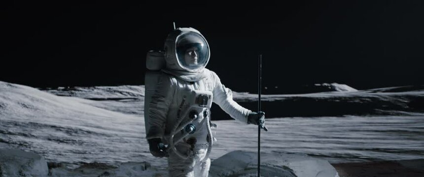 Portrait of Asian lunar astronaut standing with a flag pole on the Moon surface. Easy to track and add your flag. Shot with 2x anamorphic lens