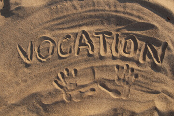 Sand on the beach and the inscription vacation