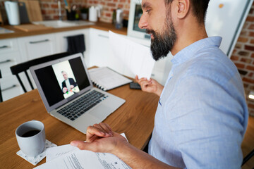 Satisfied man talking to boss on web meeting