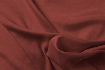 Red silk or satin luxury fabric texture can use as abstract background. Top view.