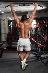 Man doing pull-ups in the gym - obrazy, fototapety, plakaty