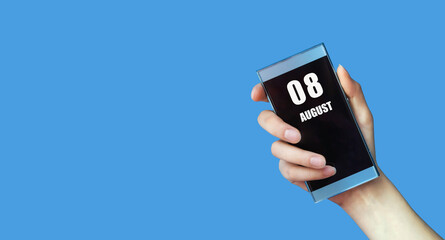 august 08. 08th day of the month, calendar date.Woman's hand holds mobile phone with blank screen on blue isolated background.Summer month, day of the year concept