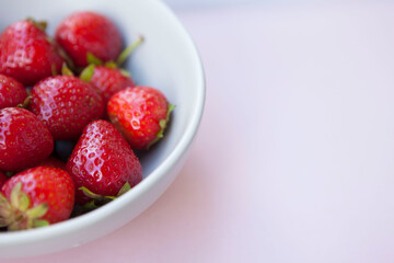 Cropped shot of a bowl with strawberries on pastel background, copy space