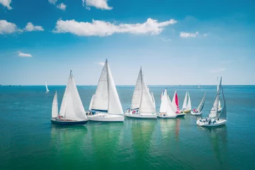 Fotobehang Regatta sailing ship yachts with white sails at opened sea. Aerial view of sailboat in windy condition © ValentinValkov