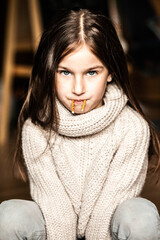 Portrait of a teenage girl in a light sweater with dark hair and blue eyes, close-up, full face