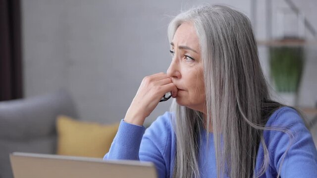Depressed mature woman overworked on laptop computer. Tired worker recieved bad online news about dismissal from work. Financial crisis, burnout syndrome, overworking, depression, apathy.
